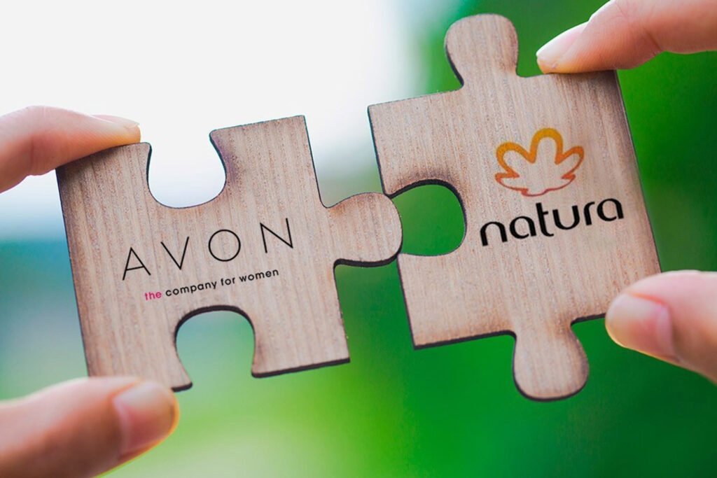 Duas peças de quebra-cabeça com as logomarcas das empresas Avon e Natura.